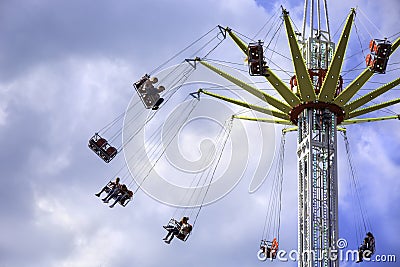 People enjoy a ride on a flying swing ride at an amusement park Editorial Stock Photo