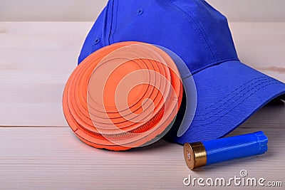 Flying target plate for shotgun sport, blue cap and a shell Stock Photo