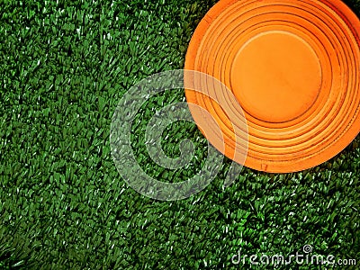 Flying target plate for shotgun sport is lying on the green grass. Stock Photo