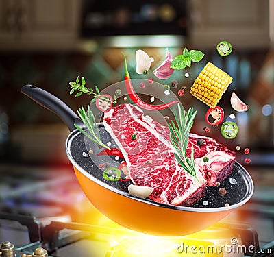 Flying tbone steaks and spices falling into a frying pan. Flying motion effect of cooking process Stock Photo