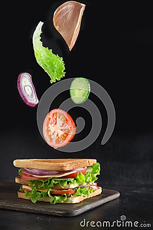 Flying ingredients for sandwich, bacon, tomato, onion, salad on black Stock Photo