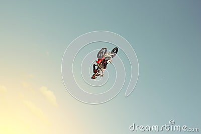 FMX biker doing a back flip on a background of blue sky Editorial Stock Photo