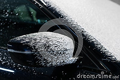 Foam drops dripping from a side mirror of a car. Stock Photo