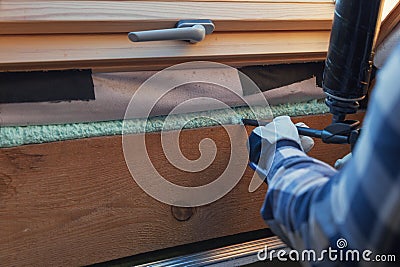 Foam window insulation on wooden construction. Building an eco-house. Heat insulation Stock Photo