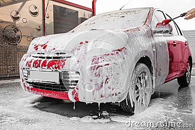 Foaming red auto at car wash Stock Photo