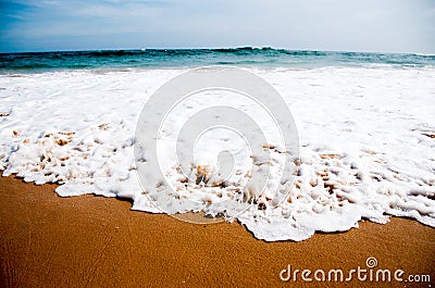 Foamy wave on beach sand Stock Photo