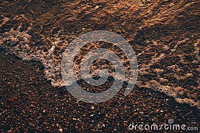Foamy wave crashing the shore at sunset, cool for background Stock Photo