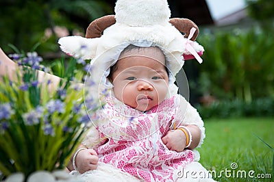 Focus at Asian newborn baby girl with costumes little sheep in the garden and mother is holding her. Stock Photo