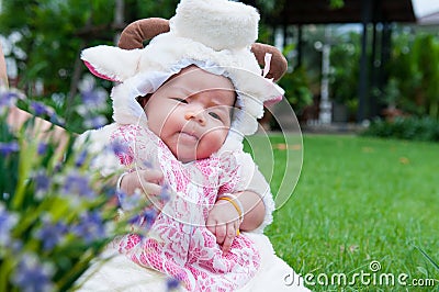 Focus at Asian newborn baby girl with costumes little sheep in the garden and mother is holding her. Stock Photo