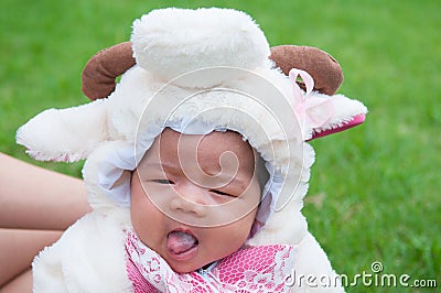 Focus at Asian newborn baby girl with costumes little sheep in the garden and mother is holding her. Stock Photo