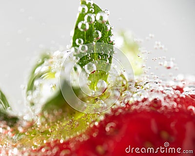 Focus of a bubbles surrounding a strawberry in a frizzy alcoholic drink Stock Photo