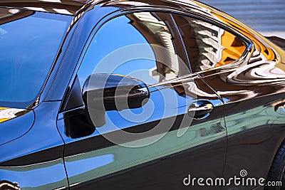 Car wing mirror with colorful reflection on surface of modern automobile black car Stock Photo