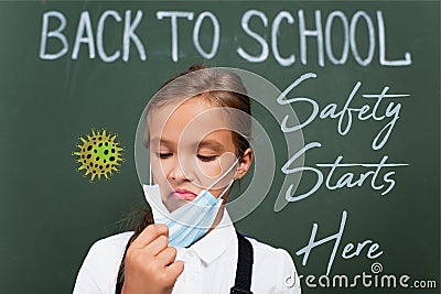 Focus of displeased schoolgirl touching protective Stock Photo