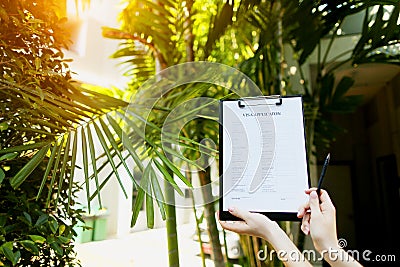 Focus on document that young girl fills out visa application form for Australia against backdrop of palm trees and sun Stock Photo