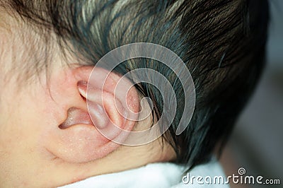 Focus at ear of Asian baby girl while sleeping. Close up at cute newborn is looking at camera Stock Photo