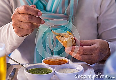 Focus on the hands of a woman enjoying the three.typical sauces of the Canary Islands, called Stock Photo