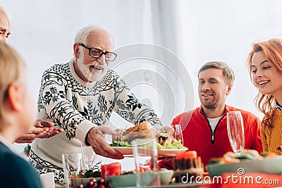 Focus of happy grandfather serving turkey Stock Photo