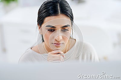 Focus always proceeds to success. High angle shot of a young businesswoman looking thoughtful while working on a Stock Photo