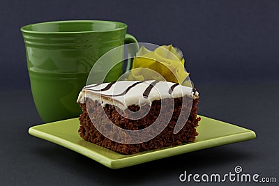 Focus on red velvet cake on green plate with mug and yellow flow Stock Photo