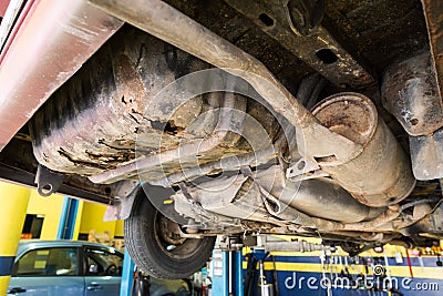 Focus on rusty, damaged, corroded undercarriage of car at workshop Stock Photo