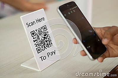 Focus on Scan here to pay text, Close up of hands Scaning QR code for digital contact less payment after shopping - Stock Photo