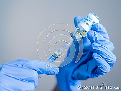 Focus on syringe, close up of doctor or nurse hands taking covid vaccination booster shot or 3rd dose from syringe Stock Photo