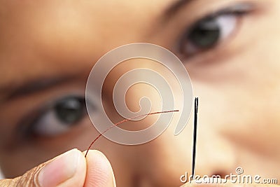 Focus to put the sewing thread into needle Stock Photo