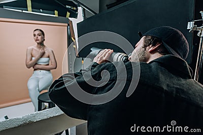 Focus of videographer filming female model in photo studio Stock Photo