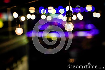 Focus on Vintage circle hanging lamp on the line with blur outdoor concert in the night bokeh background Stock Photo