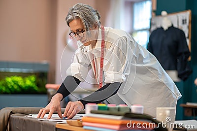 Concentrated woman standing near table drawing pattern Stock Photo