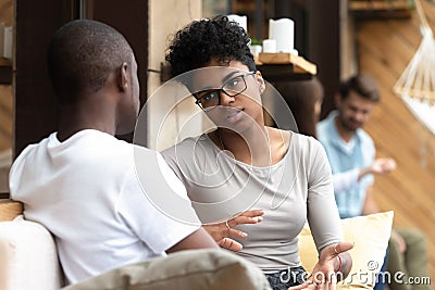 Serious African American woman talking with man in cafe Stock Photo