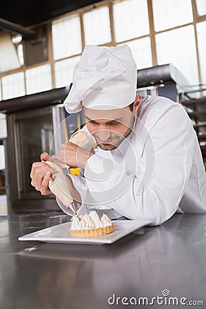 Focused baker preparing handmade cake Stock Photo