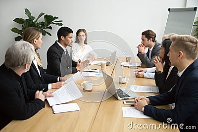 Focused black team leader talking to colleagues at group meeting Stock Photo