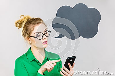Focused business woman looking at phone, thinking bubble Stock Photo