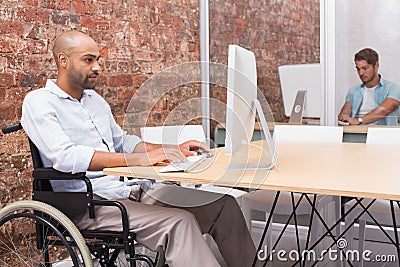 Focused businessman in wheelchair working at his desk Stock Photo