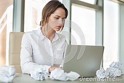 Focused businesswoman preparing report typing on laptop with cru Stock Photo