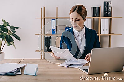 focused businesswoman in suit doing paperwork at workplace Stock Photo