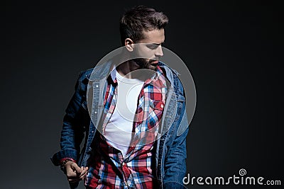 Focused casual man adjusting his jacket and looking away Stock Photo