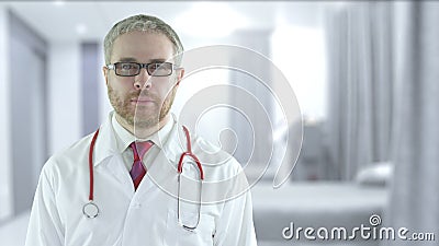 Focused doctor with red stethoscope in a modern hospital ward Stock Photo