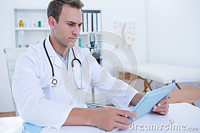 Focused doctor working with tablet computer Stock Photo