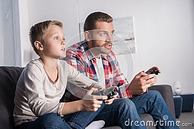 Father and son playing with joysticks Stock Photo