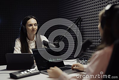 Focused Female Host Conducting Podcast Interview Stock Photo