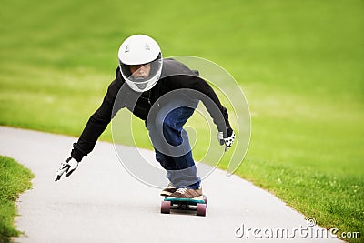 Focused on going fast. Shot of a skateboarder making his way down a lane on his board. Stock Photo