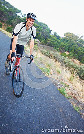Focused on his ride. Shot of a lone rider cycling down a rural road with copy space. Stock Photo