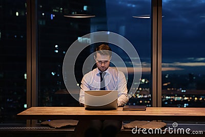 Focused male employee develop project by laptop late at evening Stock Photo