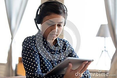 Focused millennial ethnic woman working on tablet gadget Stock Photo