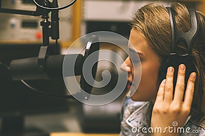 Focused pretty singer recording a song Stock Photo