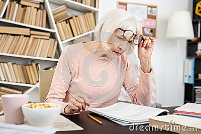Focused senior woman reading task Stock Photo