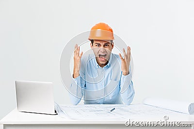 Focused serious hardworking engineer busy working on big architectural project late, sitting at his workspace using Stock Photo