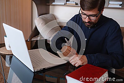 Focused serious male student using laptop looking at computer screen Stock Photo